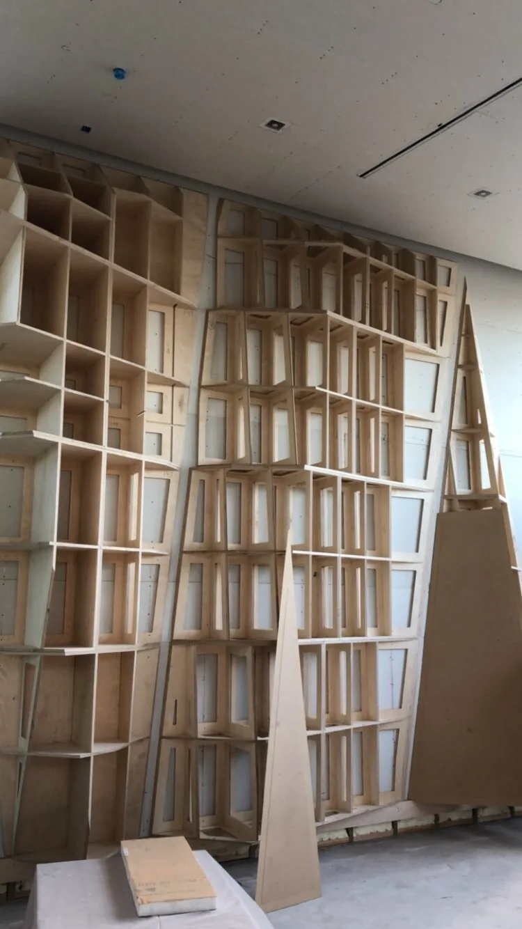 A tall plywood lattice shelving structure standing in the shop before finishing