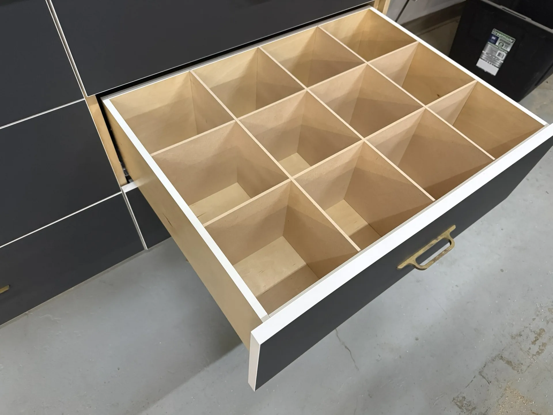 A deep drawer pulled open to show a twelve-compartment divider insert