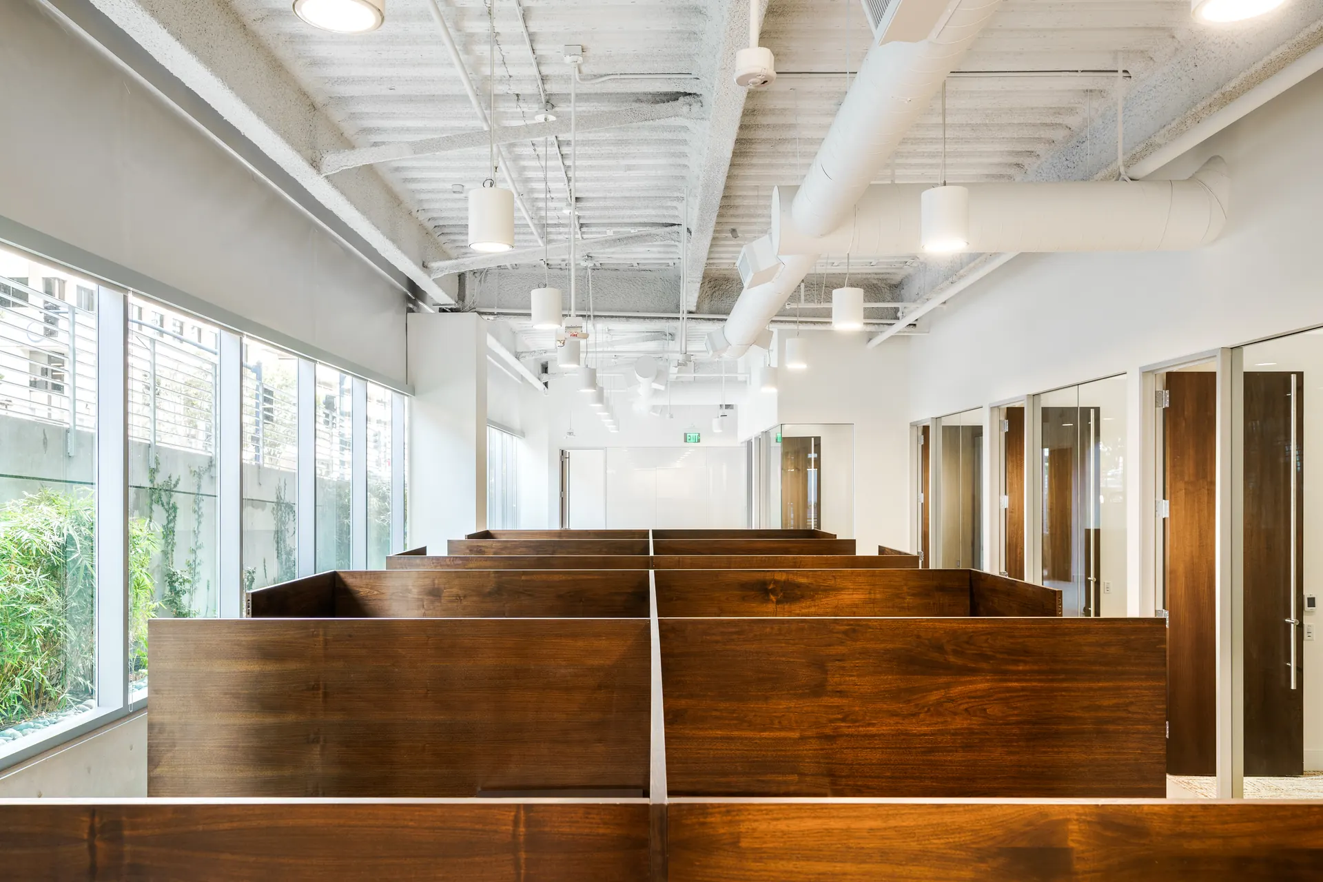 Walnut partition walls dividing an open office floor along a window wall